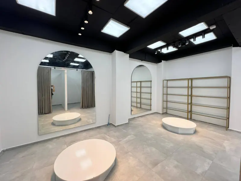 Interior space with arched mirrors, fitted shelving and contemporary lighting